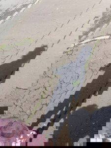A shadow of a child on a cracked pavement